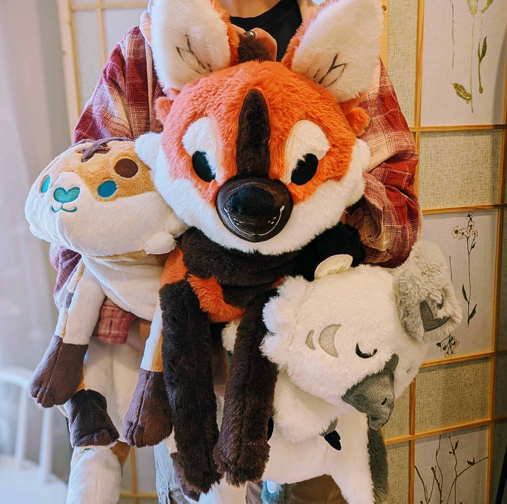 Weighted plush toys of Paprika the maned wolf, Cornflakes the tiger shark, and Sesame the gryphon