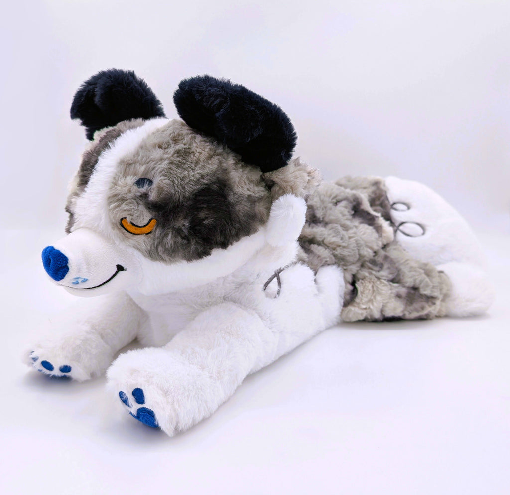 Plush toy of a blue merle border collie with a blue nose and yellow eye
