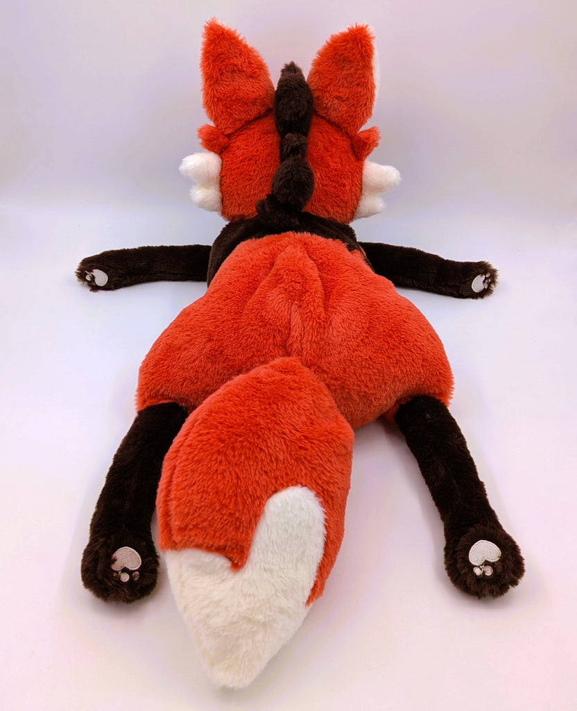 Back view of a plush toy of Paprika the maned wolf