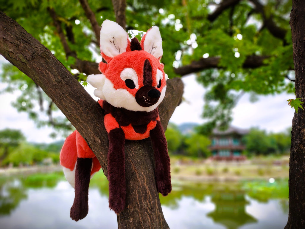 Plush toy of Paprika the maned wolf lying in a tree