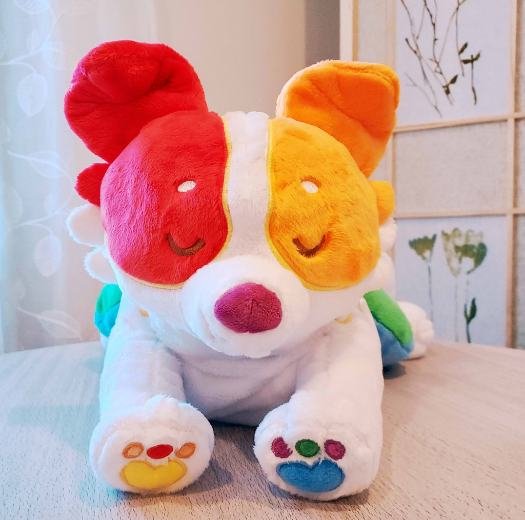 Weighted plush pillow of Jellybeans the rainbow pride border collie lying down.