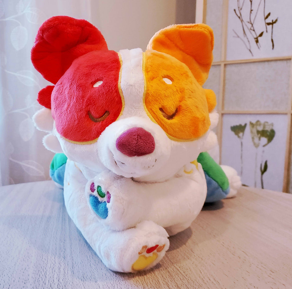 Weighted plush pillow of Jellybeans the rainbow pride border collie lying down with his paws crossed