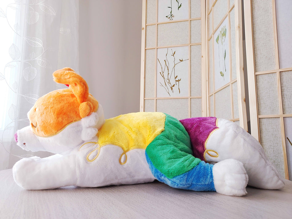 Side view of weighted plush pillow of Jellybeans the rainbow pride border collie lying down.