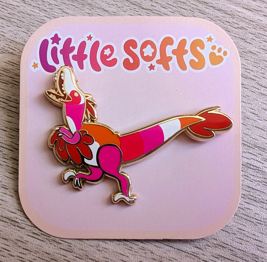 Enamel pin of Citrus Splash the orange, pink, white, and red utahraptor