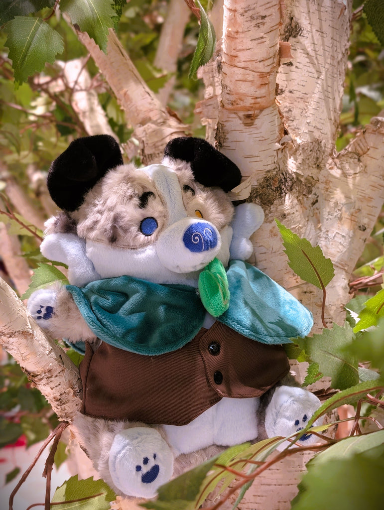 CosyPaws plush of Stormy Pup the blue merle border collie, wearing a green cape