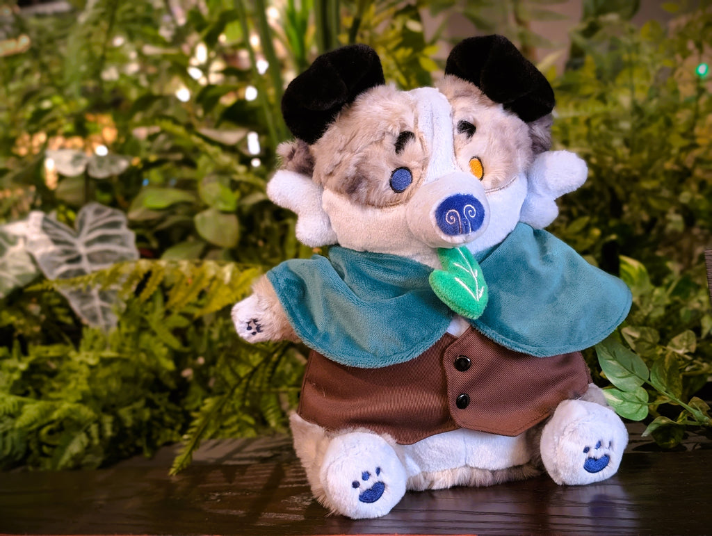 CosyPaws plush of Stormy Pup the blue merle border collie, wearing a green cape