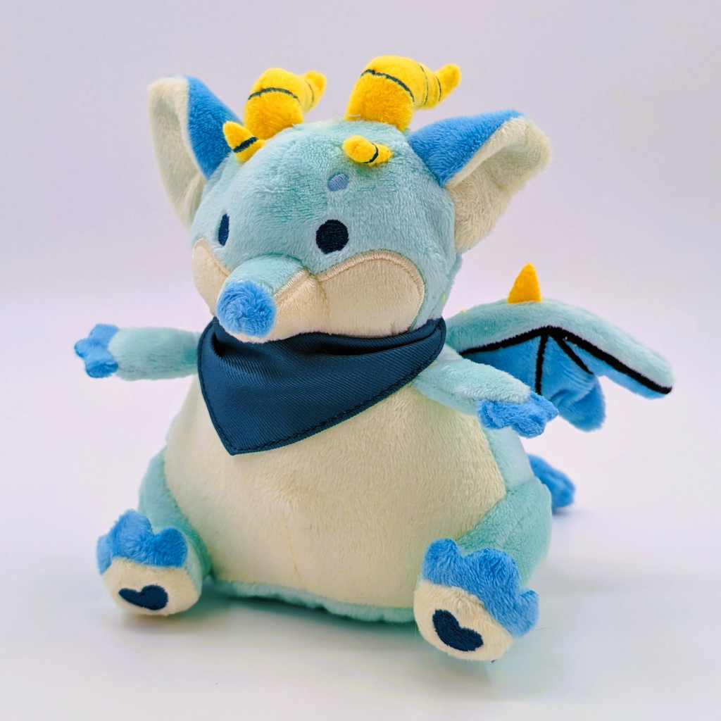 Plush toy of a green dragon wearing a green bandana