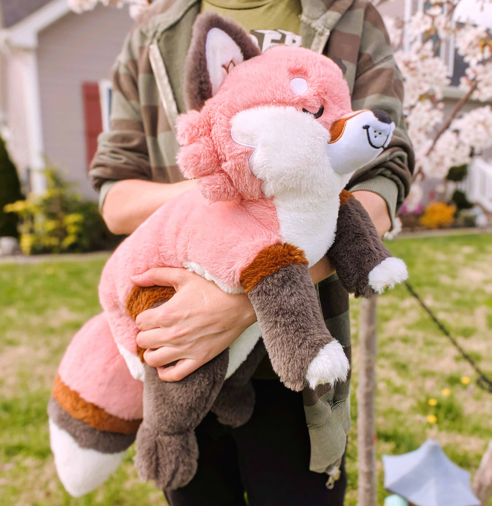 Plush toy of Chiffon the red fox being held by a person