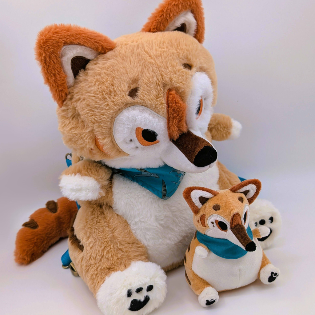 Two plush toy thylacines with a larger one sitting behind a smaller one on a white background.