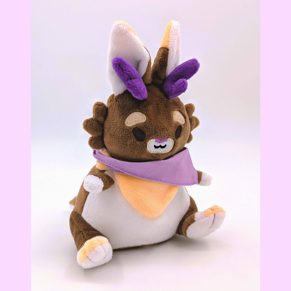 Plush toy of a jackalope with a brown and white design, purple accents, and a white background
