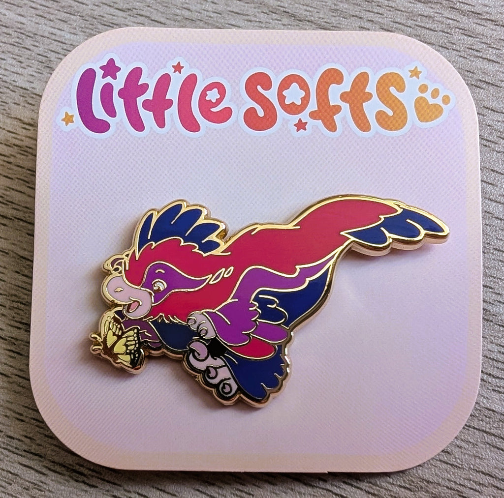 Enamel pin of Jelly Donut the pink, blue, and purple utahraptor