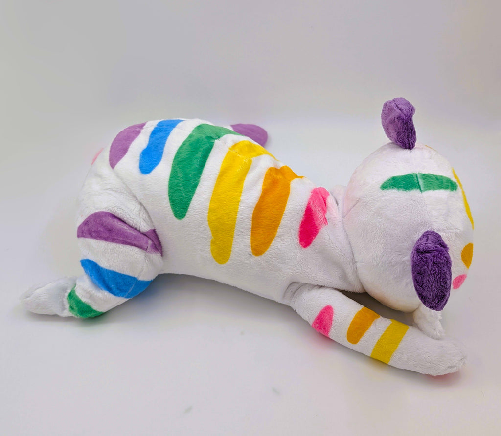 Side view of a plush toy of Mochi the pastel rainbow tiger