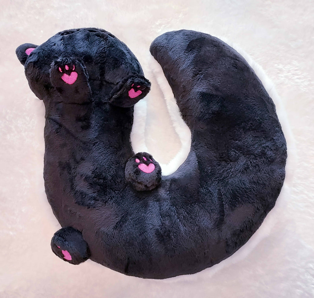 Bottom view of plush neck pillow of Snickerdoodle the skunk