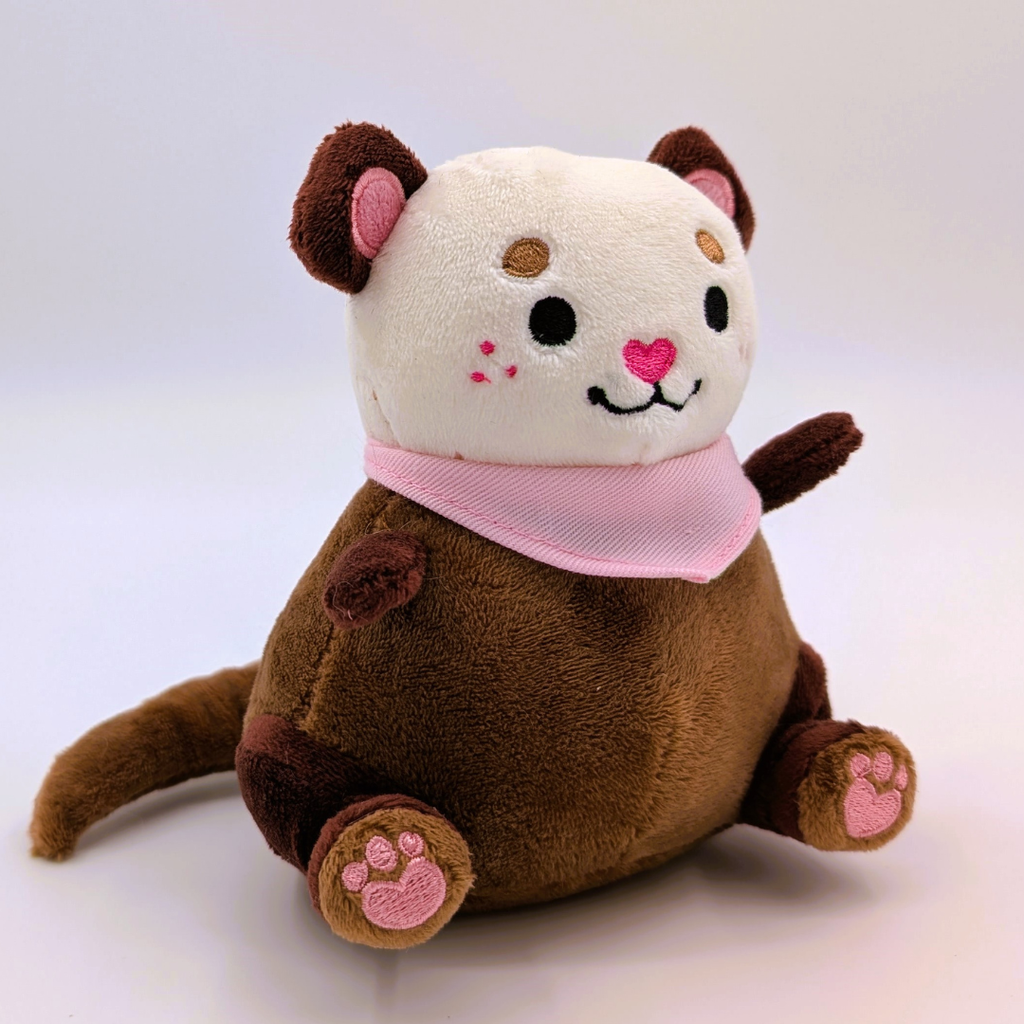 Plush toy otter with a pink bandana on a white background