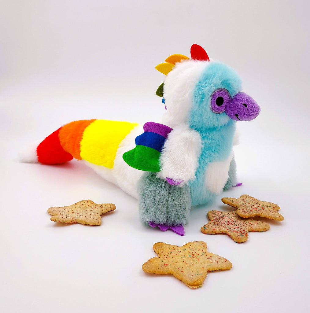 Plush toy of Sugar Cookie the Rainbow Utahraptor dinosaur with sugar cookies with sprinkles