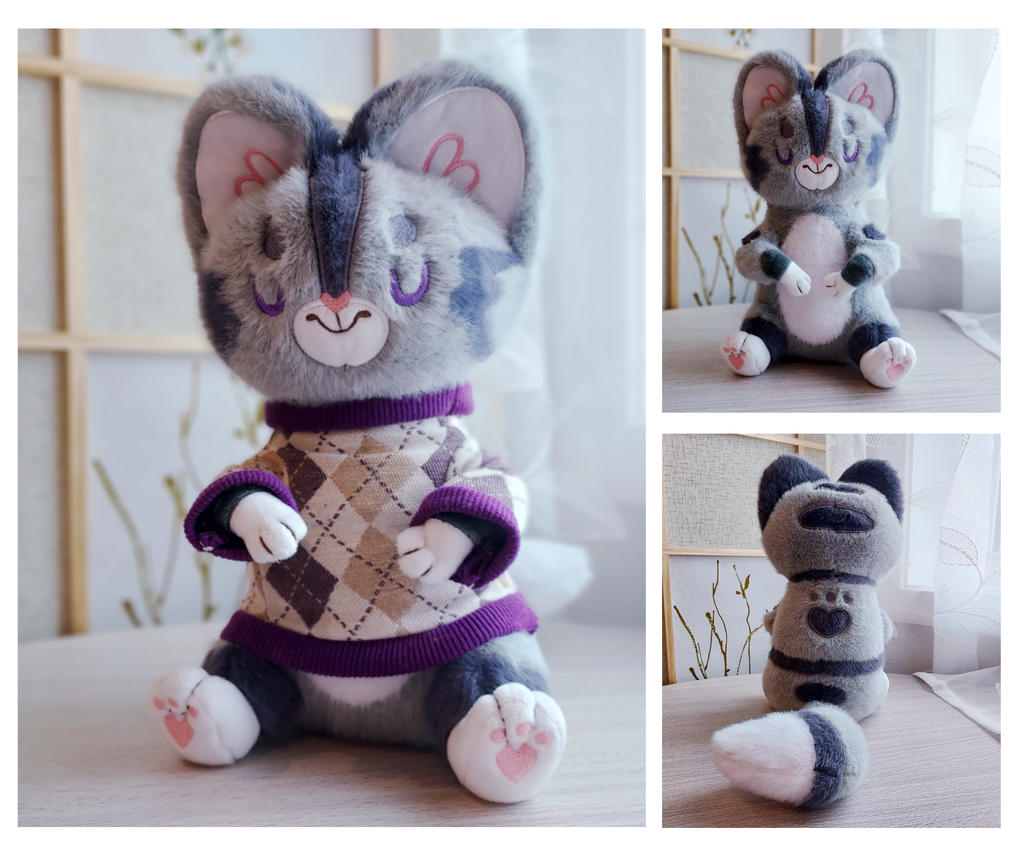 Front and back views of plush of Domino the grey tabby cat wearing a purple argyle sweater
