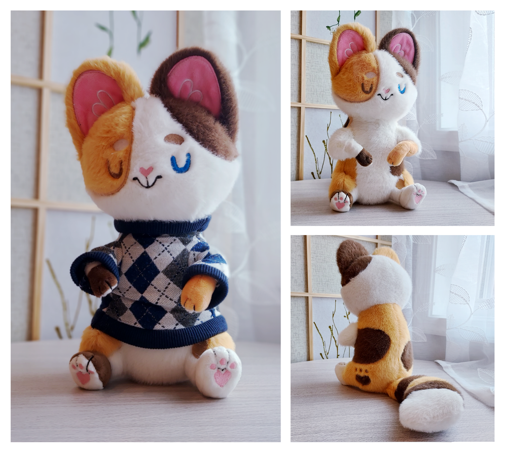 Front and back views of plush of Doodle the calico cat wearing a blue argyle sweater