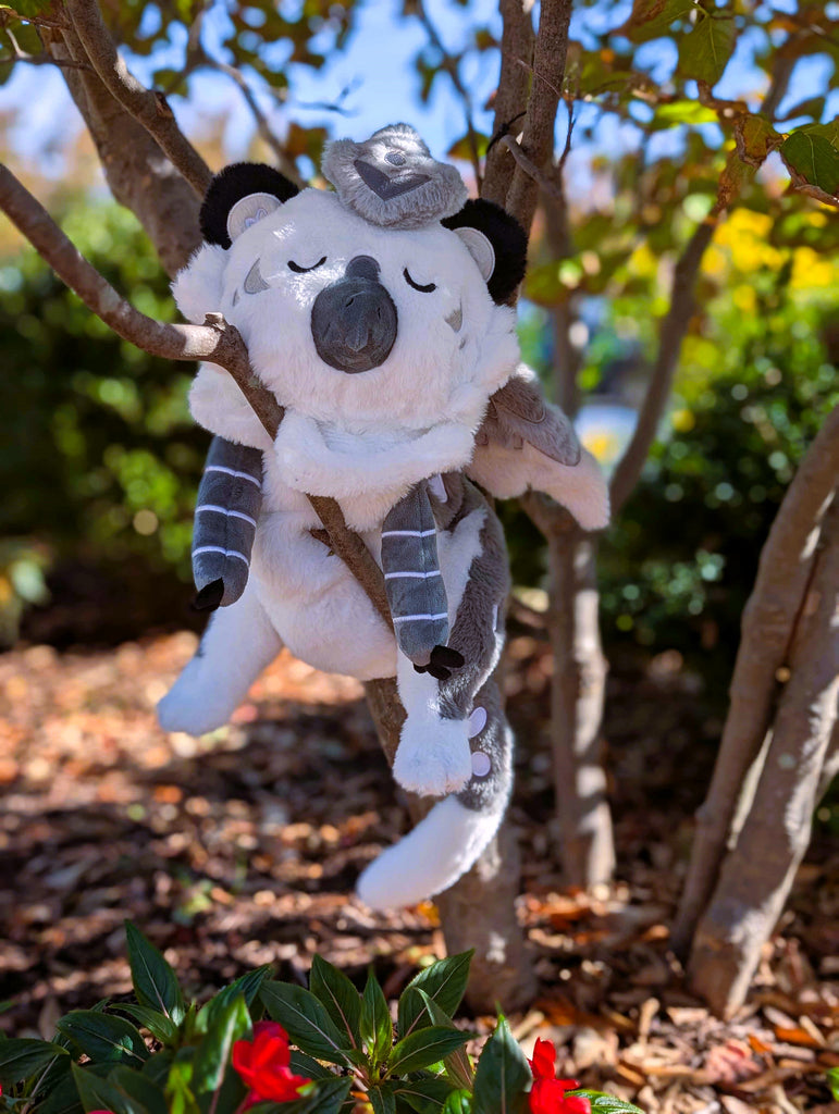 Plush toy of Sesame the grey and white gryphon resting in a tree