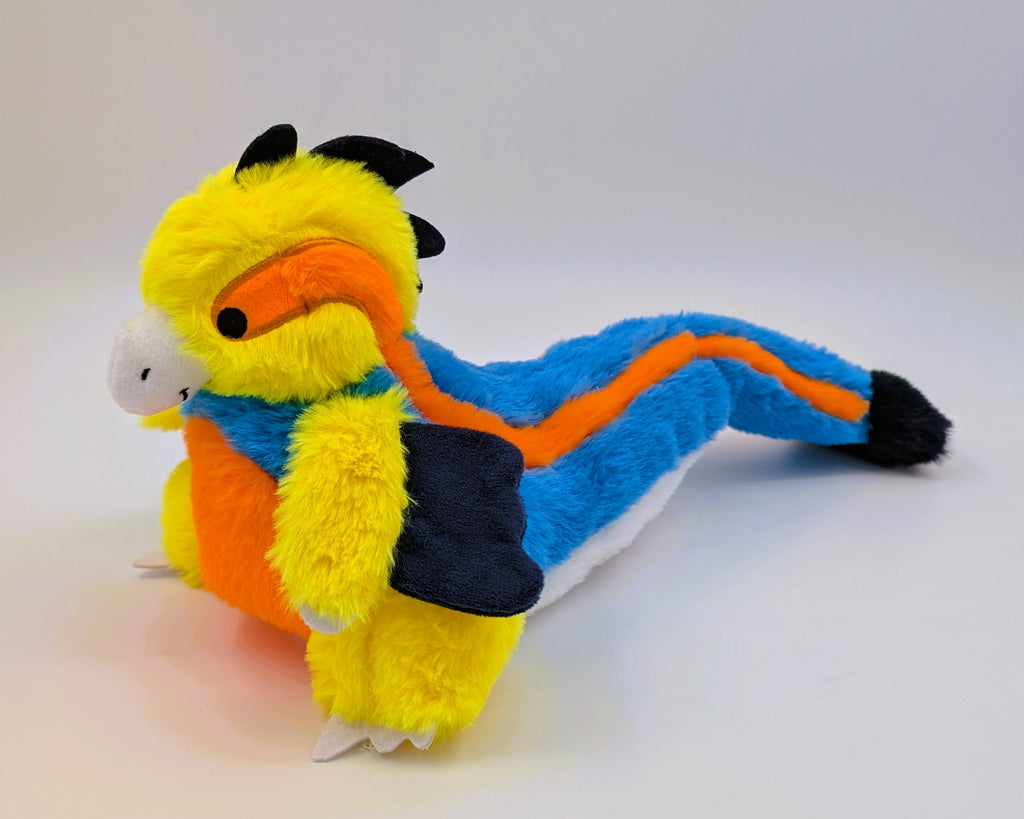 Plush toy of Slushie the blue, orange, yellow, and white utahraptor