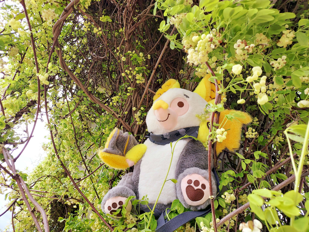 Plush backpack of Lemon the bat sitting in a tree