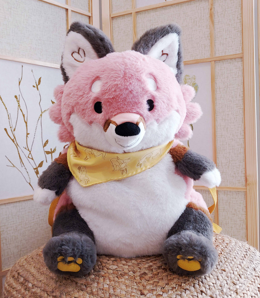 Plush backpack of Chiffon the fox wearing a yellow bandana, with yellow backpack straps