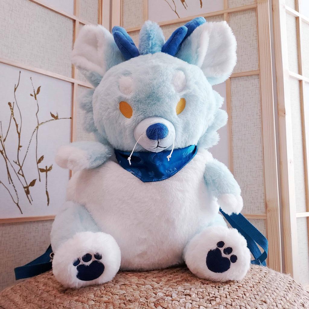 Plush backpack of Cloud the blue dragon wearing a blue bandana, with blue backpack straps