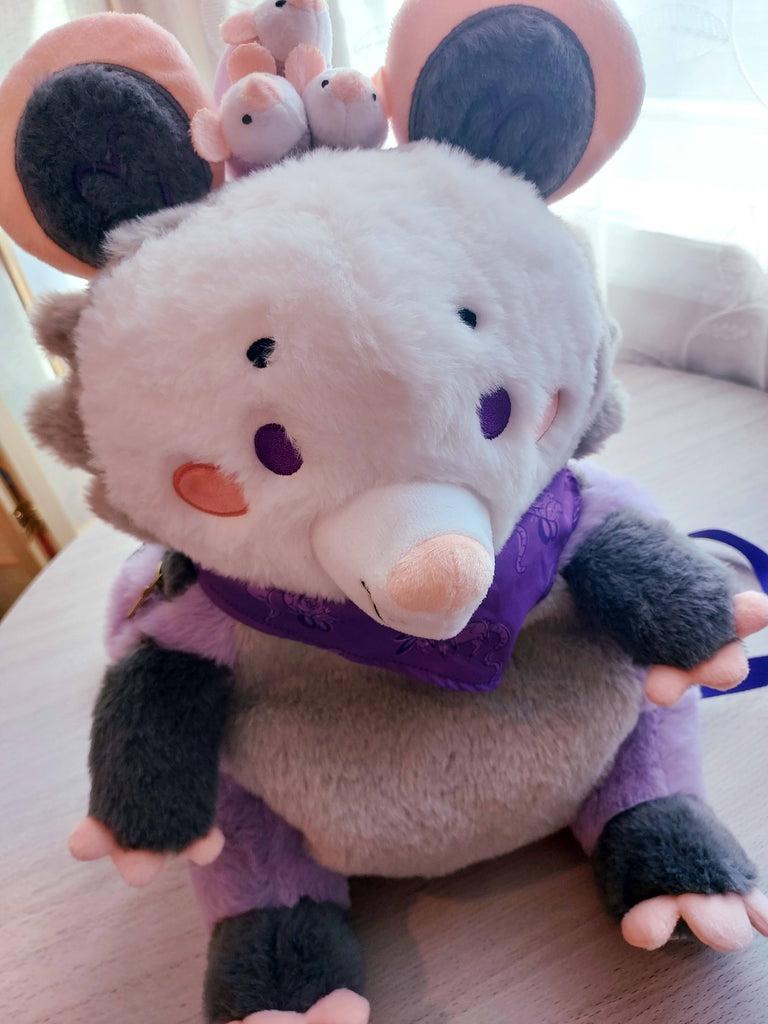 Selfie angle shot of a plush backpack of Plum the possum