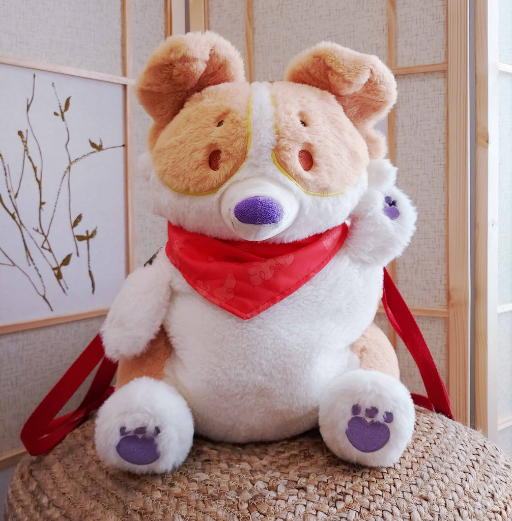 Plush backpack of Sunny Pup the red border collie wearing a red bandana, with red backpack straps