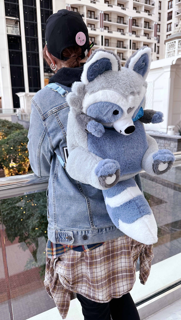 Person wearing a plush backpack of Peanut the raccoon overlooking a hotel lobby