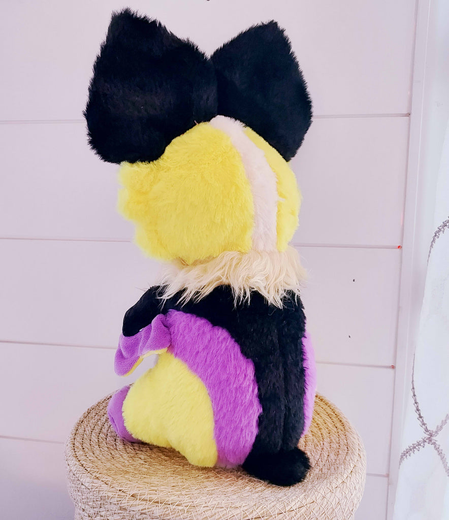 Back view of Butter the bat plush who is purple, black, yellow, and white