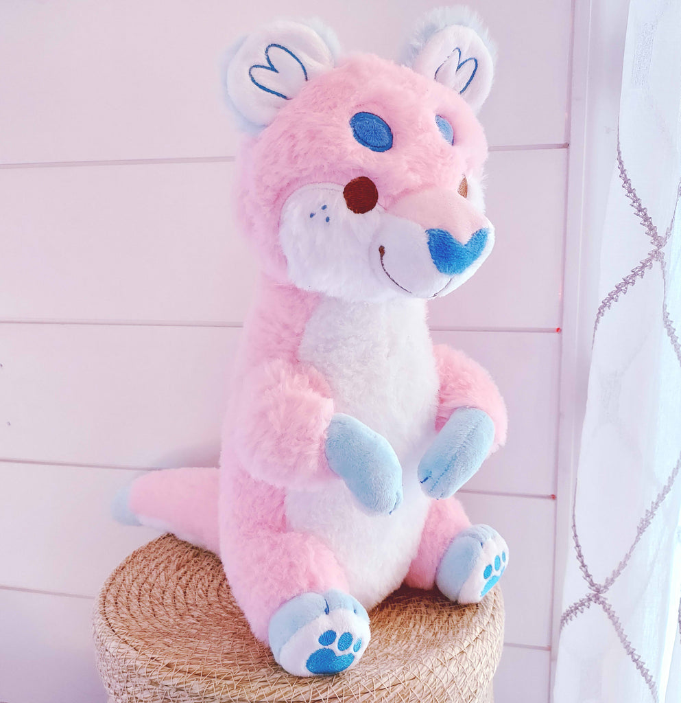 Plush toy of Cake Pop the otter who is pink, white, and blue 