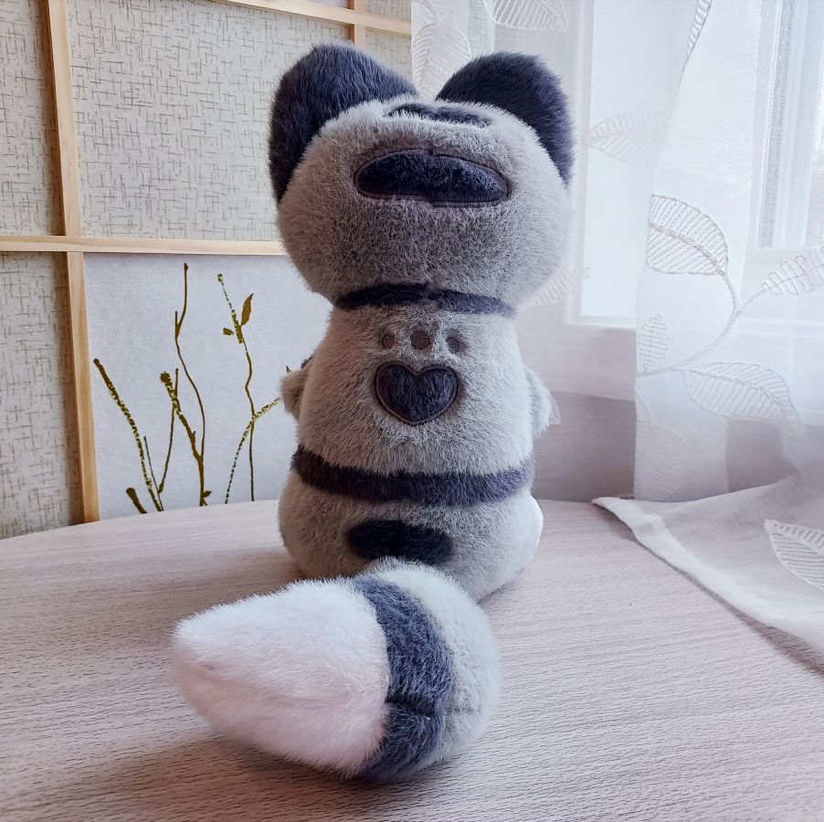 Back view of plush toy of Domino the grey tabby cat plush with a heart shaped paw print marking in his fur