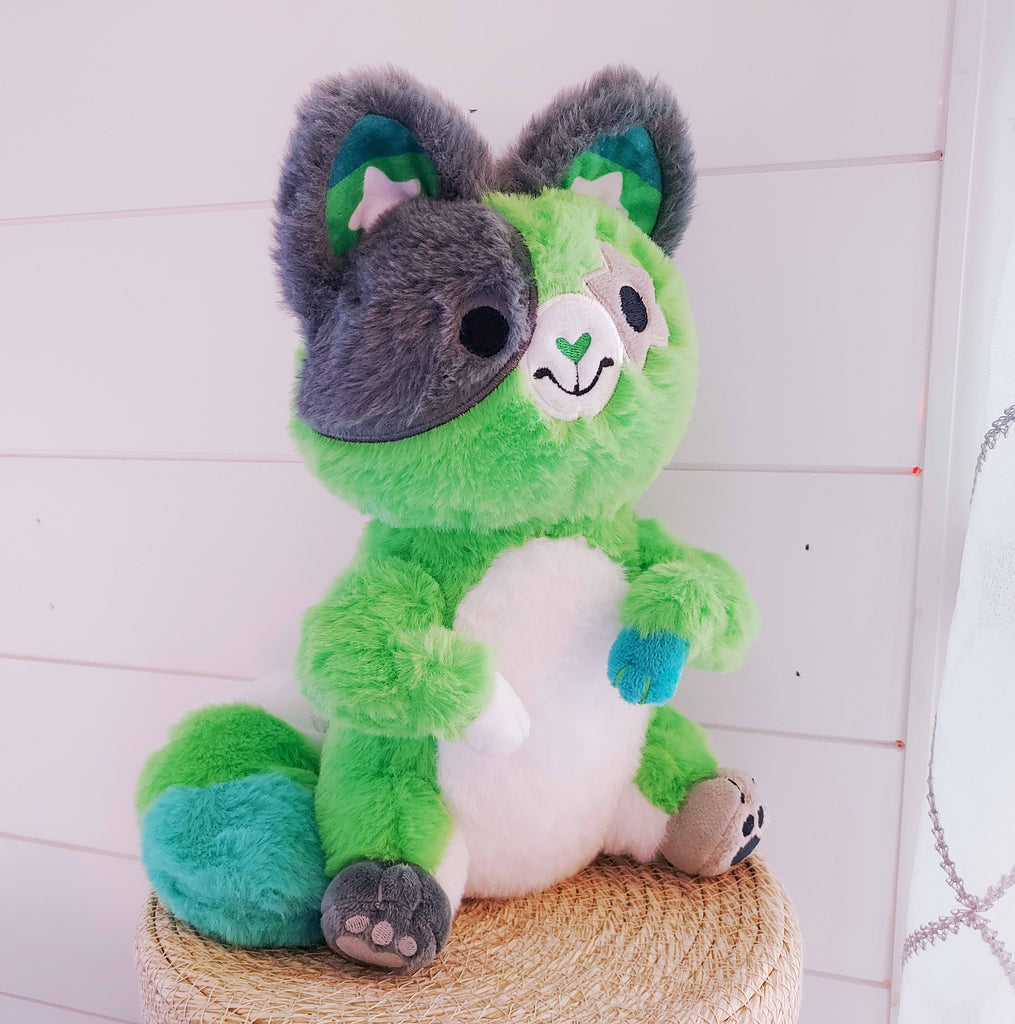 Plush toy of Matcha the cat who is green, black, white, and grey