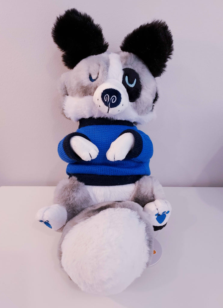 Plush toy of a blue merle border collie with blue feet pads and a blue and black sweater