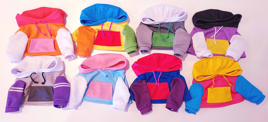 Eight hoodies for Snuggle Paws plush toys in a variety of colors