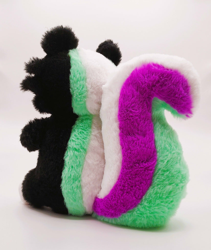 Back view of a plush toy of Pepper the green, purple, and white skunk