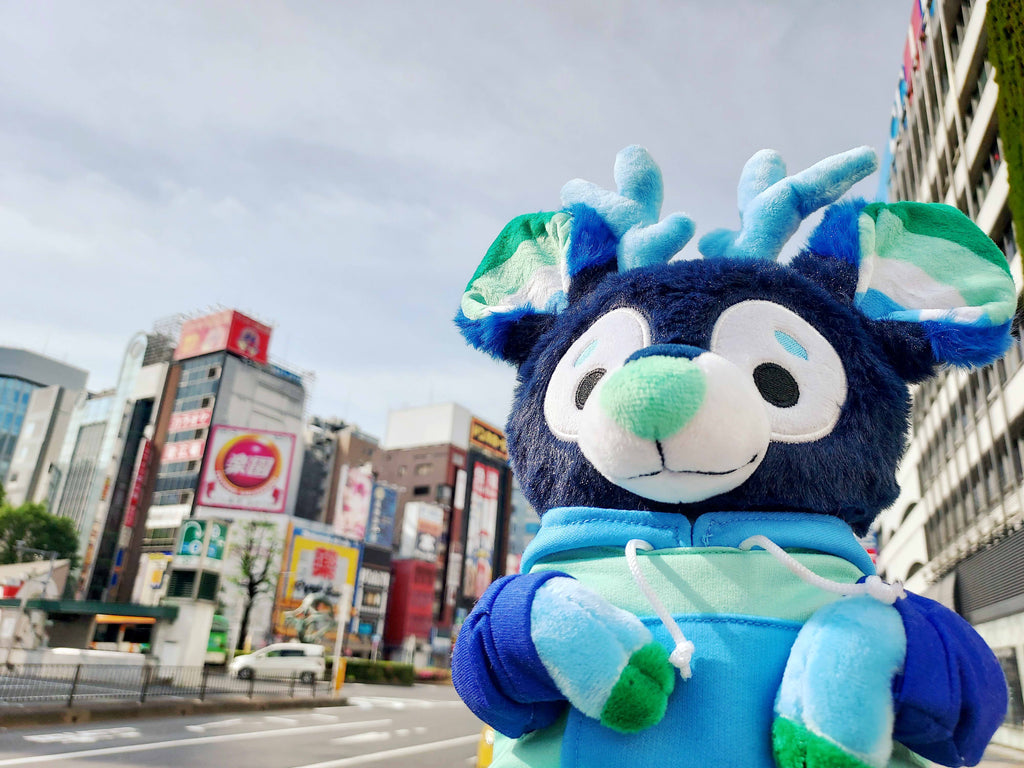 Plush toy of Smoothie the blue and green stag in the city 