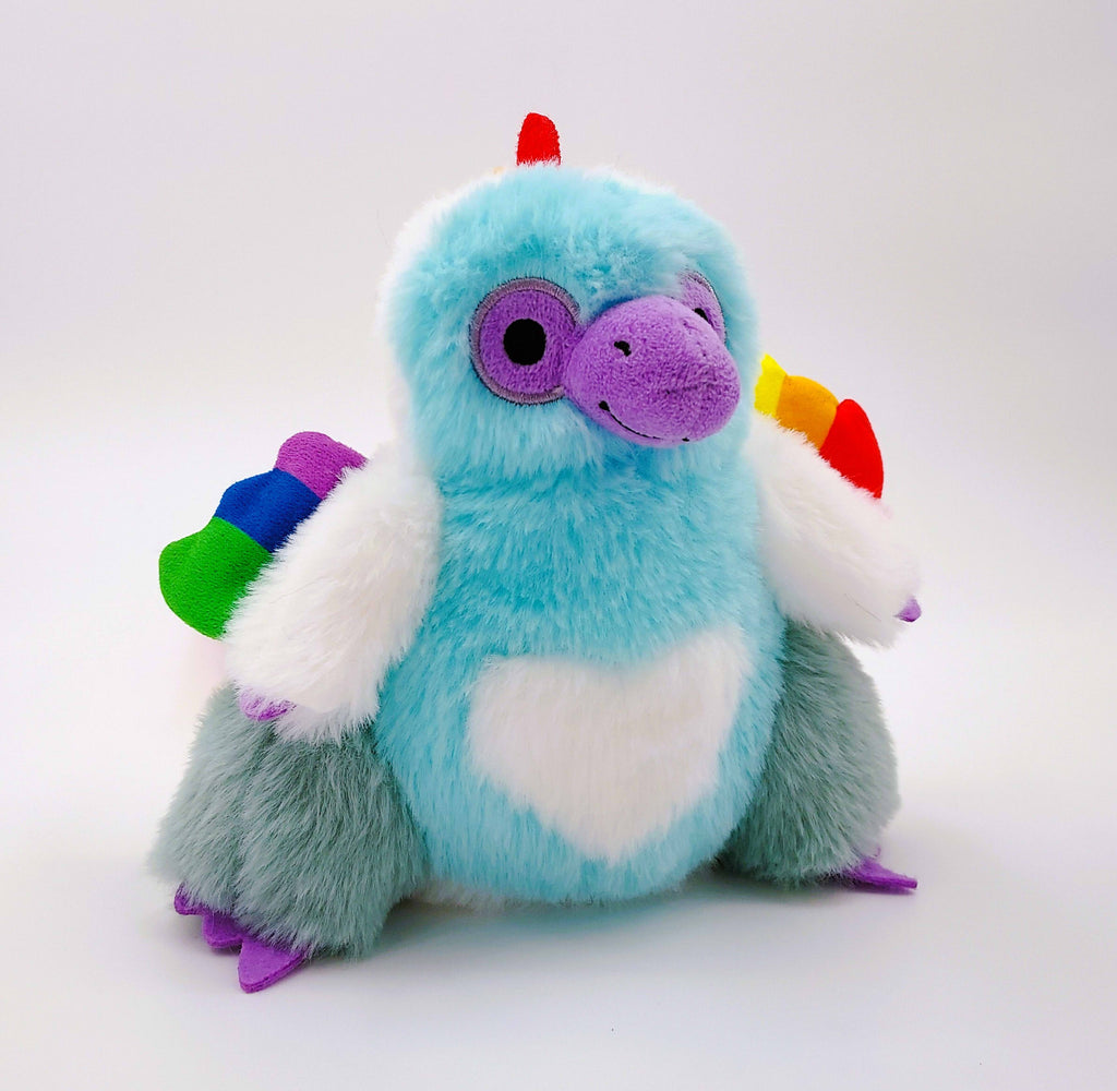 Plush toy of Sugar Cookie the Rainbow raptor dinosaur