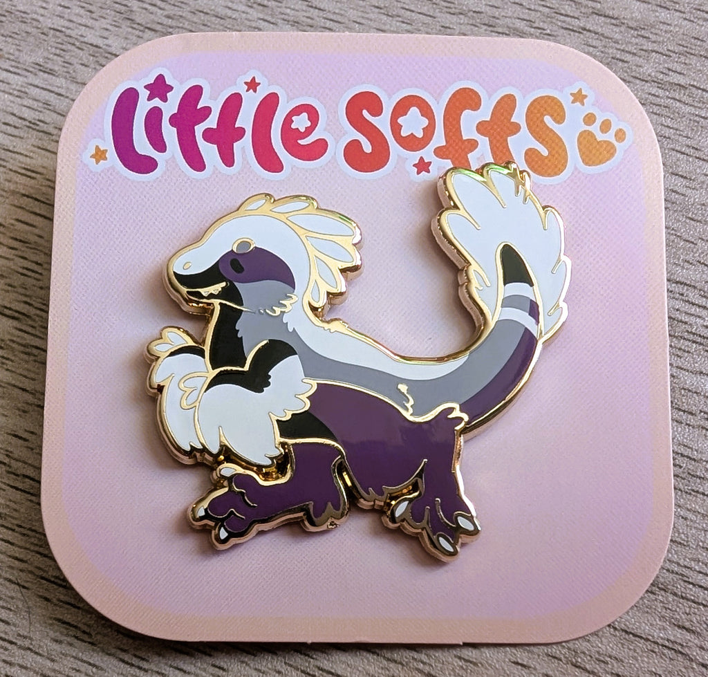 Enamel pin of Sugar Plum the black, white, grey, and purple utahraptor