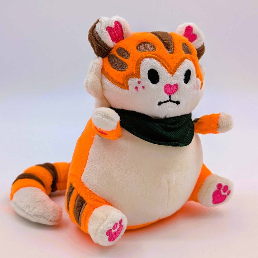 Plush toy tiger with a black scarf on a light gray background
