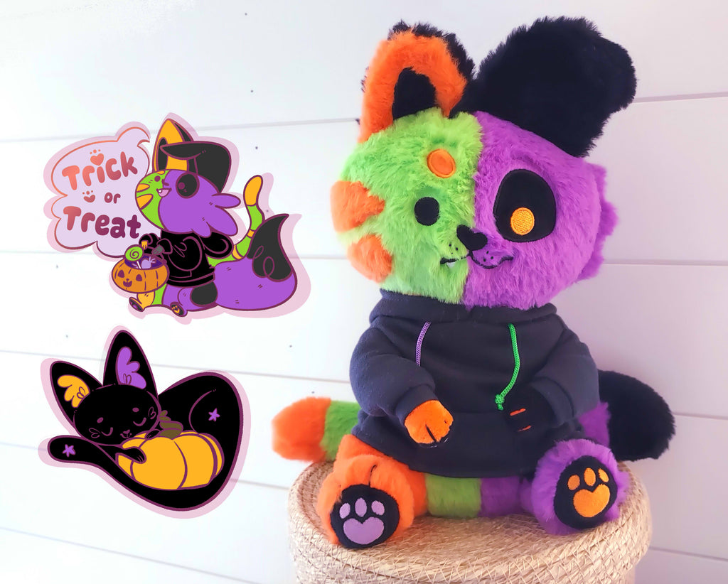 Halloween bundle featuring Them the monstrous abomination plush, a matching pin that says "Trick or Treat," and a pin of Pumpkin Purr the black cat holding a pumpkin. Them is half green and orange cat and half black and purple dog.