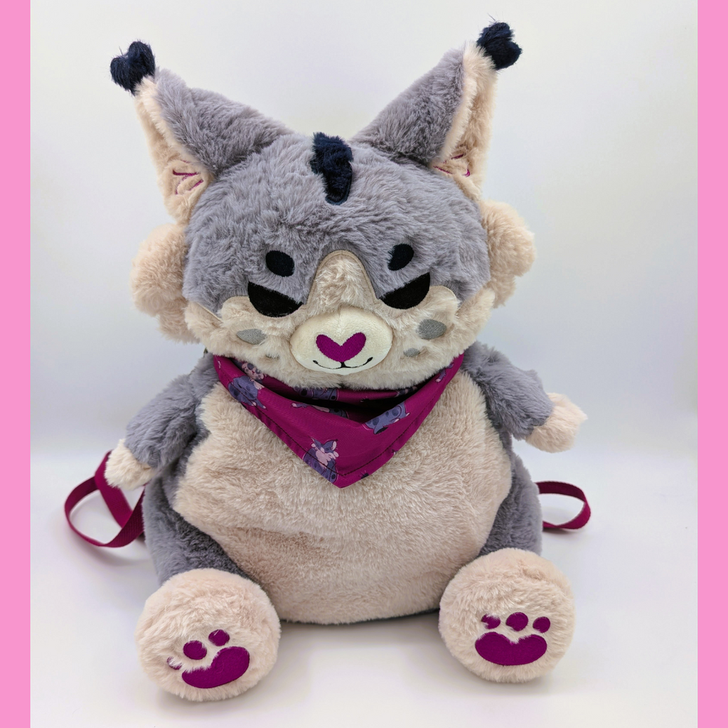 Plush backpack of a grey lynx wearing a aubergine bandana with matching paw pads  