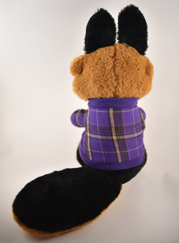 Back view of a plush toy of a german shepherd dog wearing a purple plaid sweater