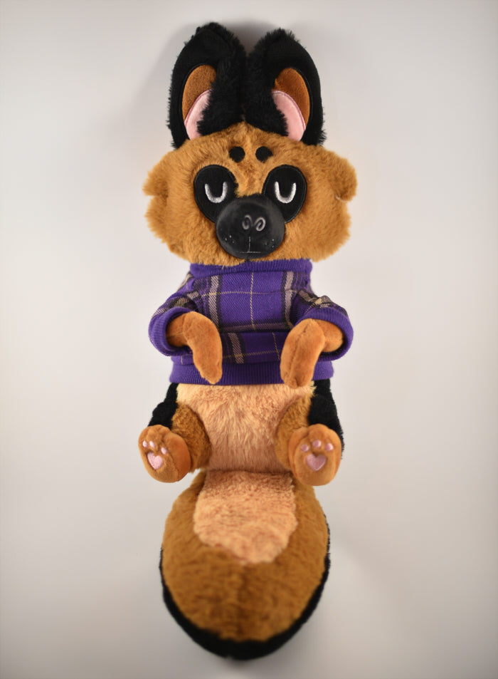 Plush toy of a german shepherd dog wearing a purple plaid sweater