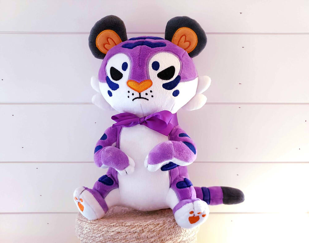 Plush toy of Lotus the purple tiger wearing a purple bow